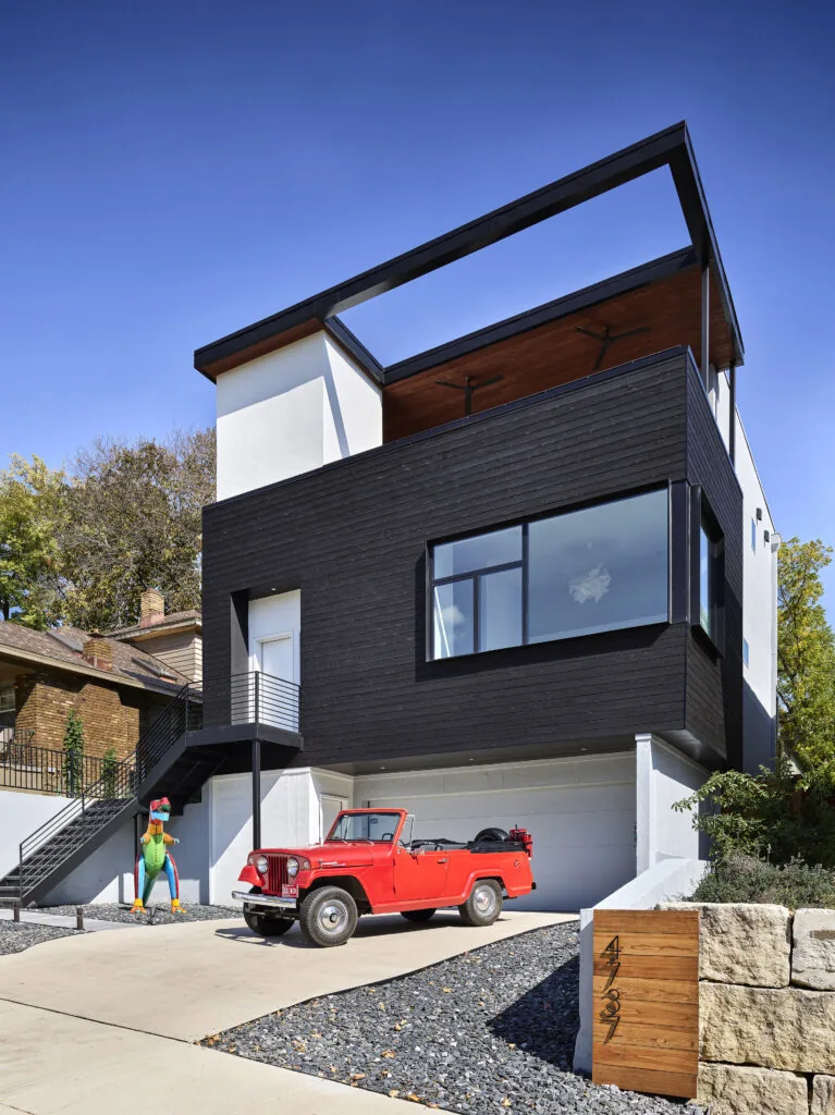 West Plaza Residence showcases a modern black and white exterior with large windows and an upper covered balcony.
