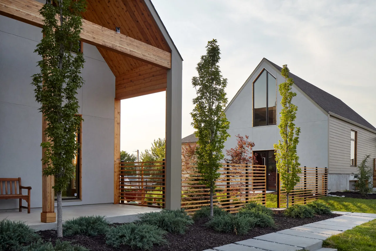 The Quackenbush Residence and Artist Studio features a modern design with a large wood overhang and horizontal wood slat fencing.