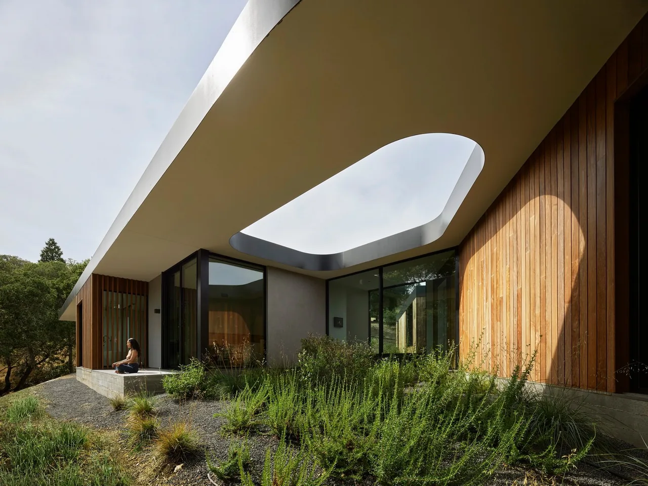 Westridge house by Ehrlich Architects features an open courtyard roof cutout and slatted wood screen with landscaped hillside surroundings.