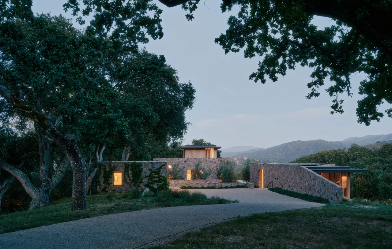 The Stone Villa features natural stone exterior walls and is situated in a wooded hillside setting with mountain views.