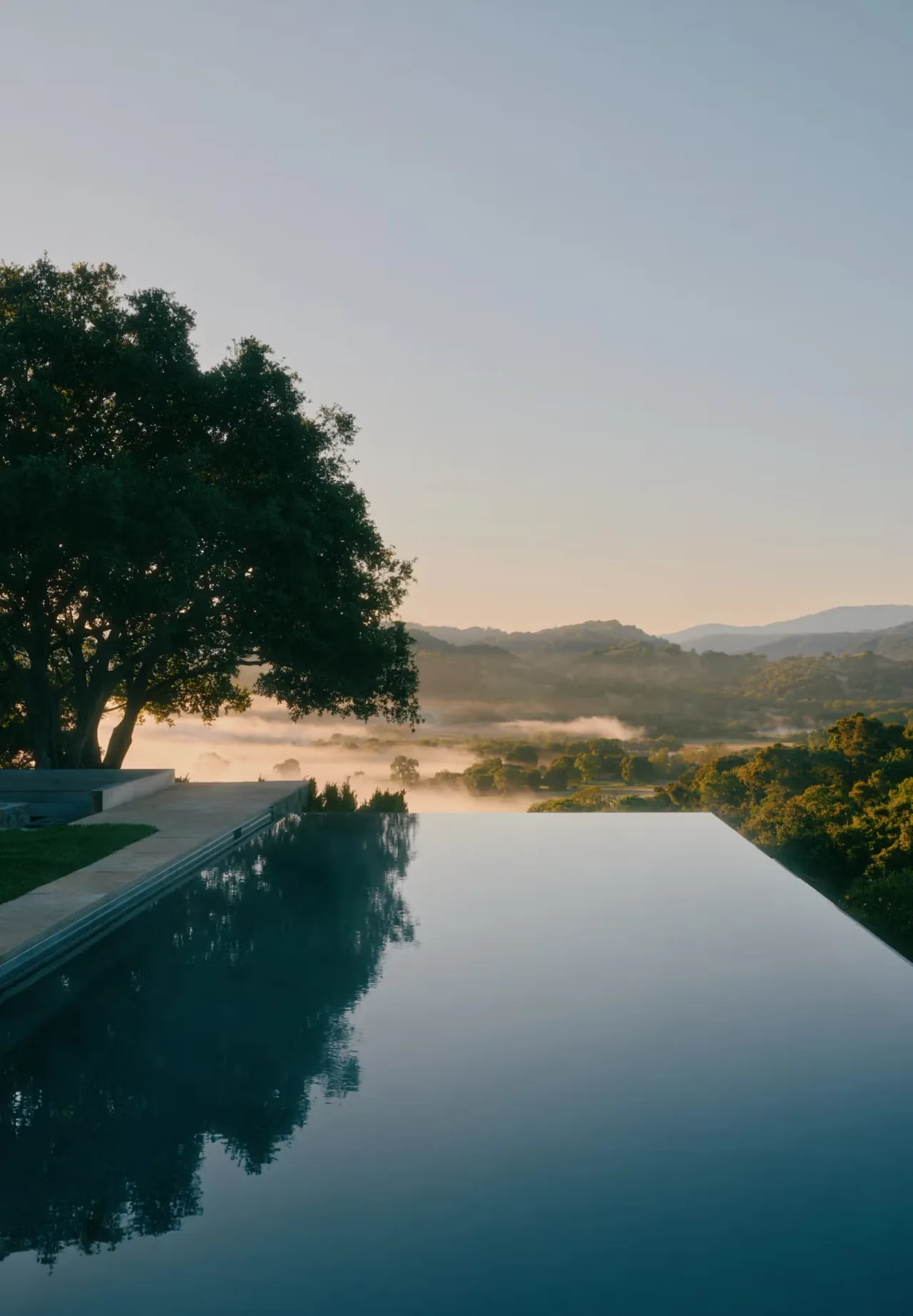 Infinity edge pool with view of hillside and mist at Stone Villa.