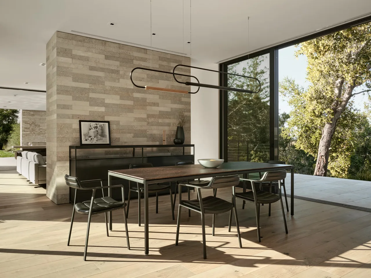 The Guzhai dining area features minimalist furniture with large sliding glass doors connecting to the outdoors.