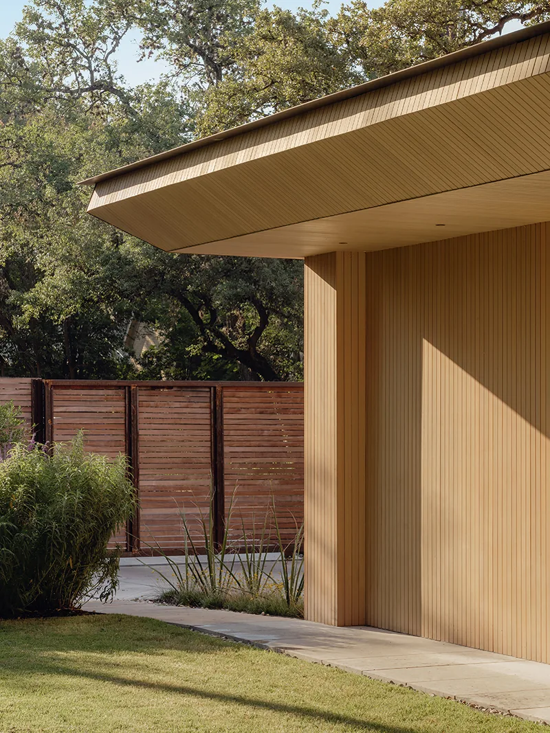 Exterior detail of Greenbelt Residence showing vertical wood siding and cantilevered roof.