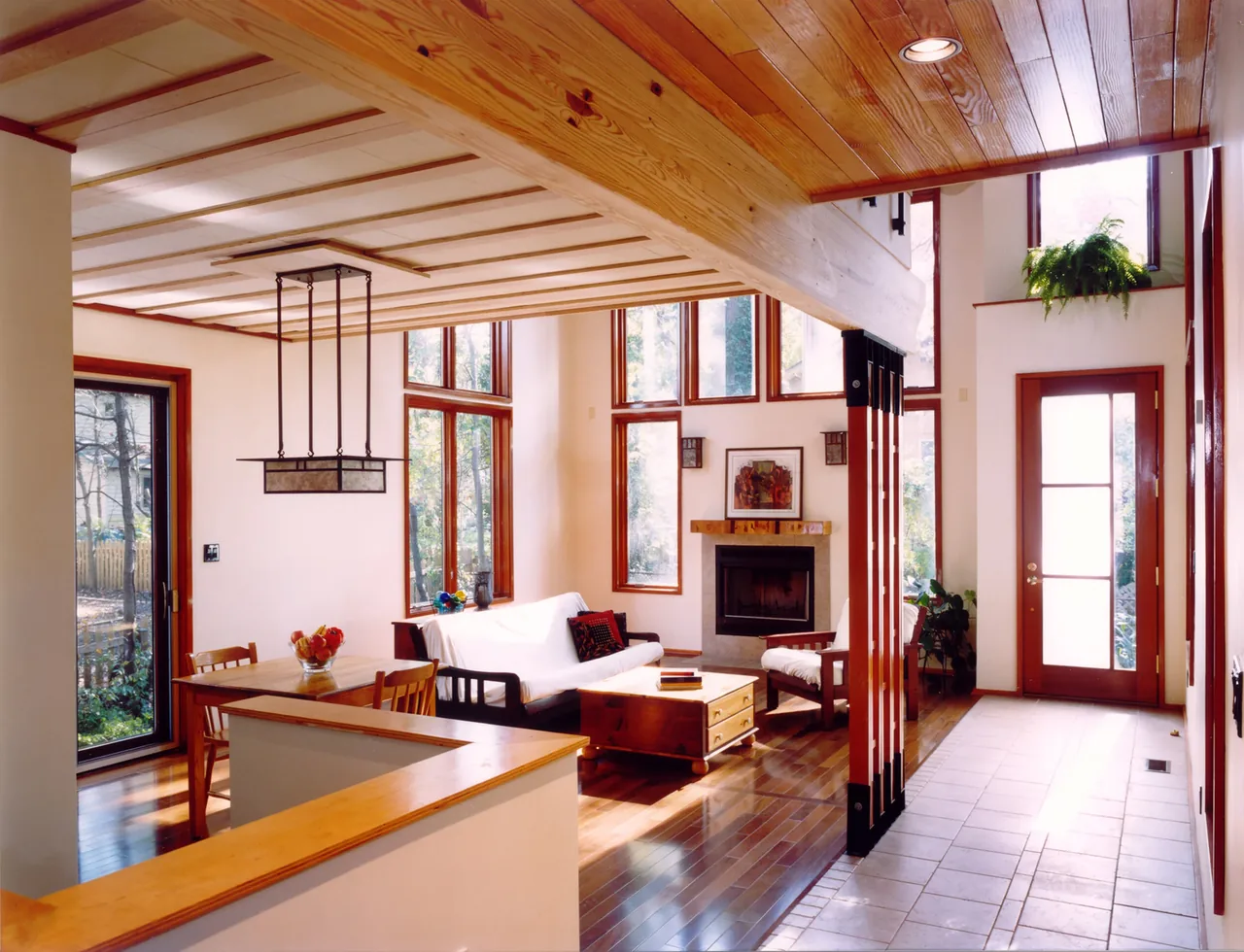 Perch House interior features wood ceilings, floor-to-ceiling windows, and a fireplace in the living area.