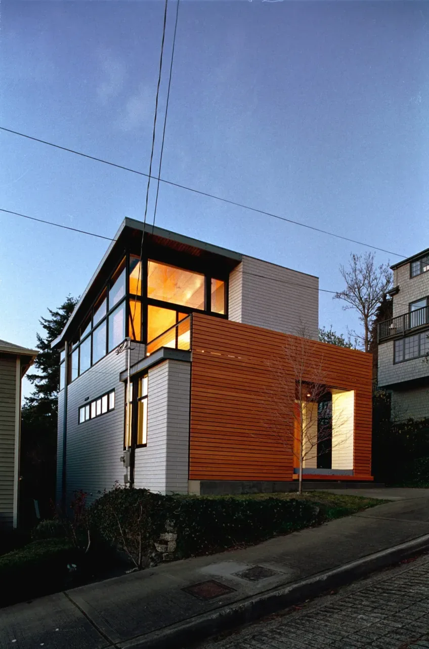 Modern house named Cavehill by Eggleston Farkas Architects features horizontal wood siding and large glass windows.