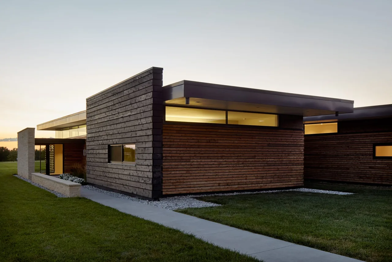 Byers Residence exterior by el dorado inc features dark horizontal wood siding and clerestory windows under a flat roof.