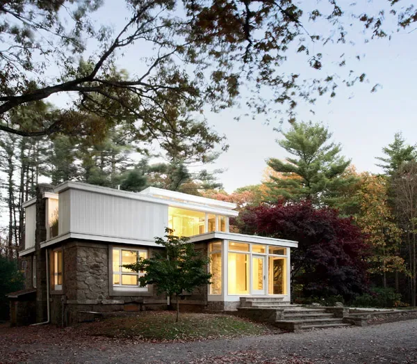 The Coulter House features a combination of stone and white siding with expansive windows, designed by SsD Architects.