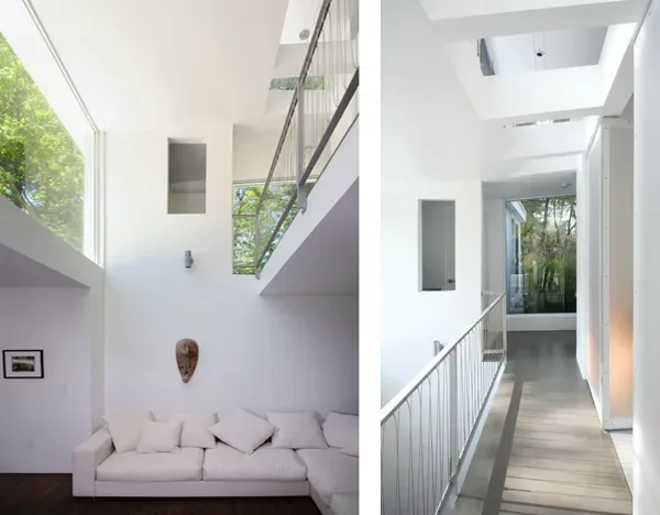 Coulter House features a white living room with a sofa under a high ceiling and a narrow hallway with natural light from skylights.