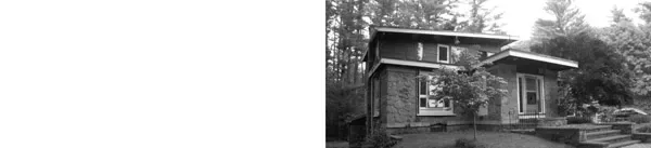 Coulter House by SsD Architects features stone exterior and flat roof in a wooded setting.