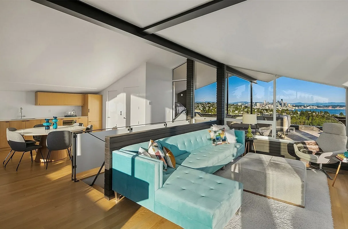 Open living and dining space with floor-to-ceiling windows offering a city skyline and water view at CRESTMONT with BAAN design.