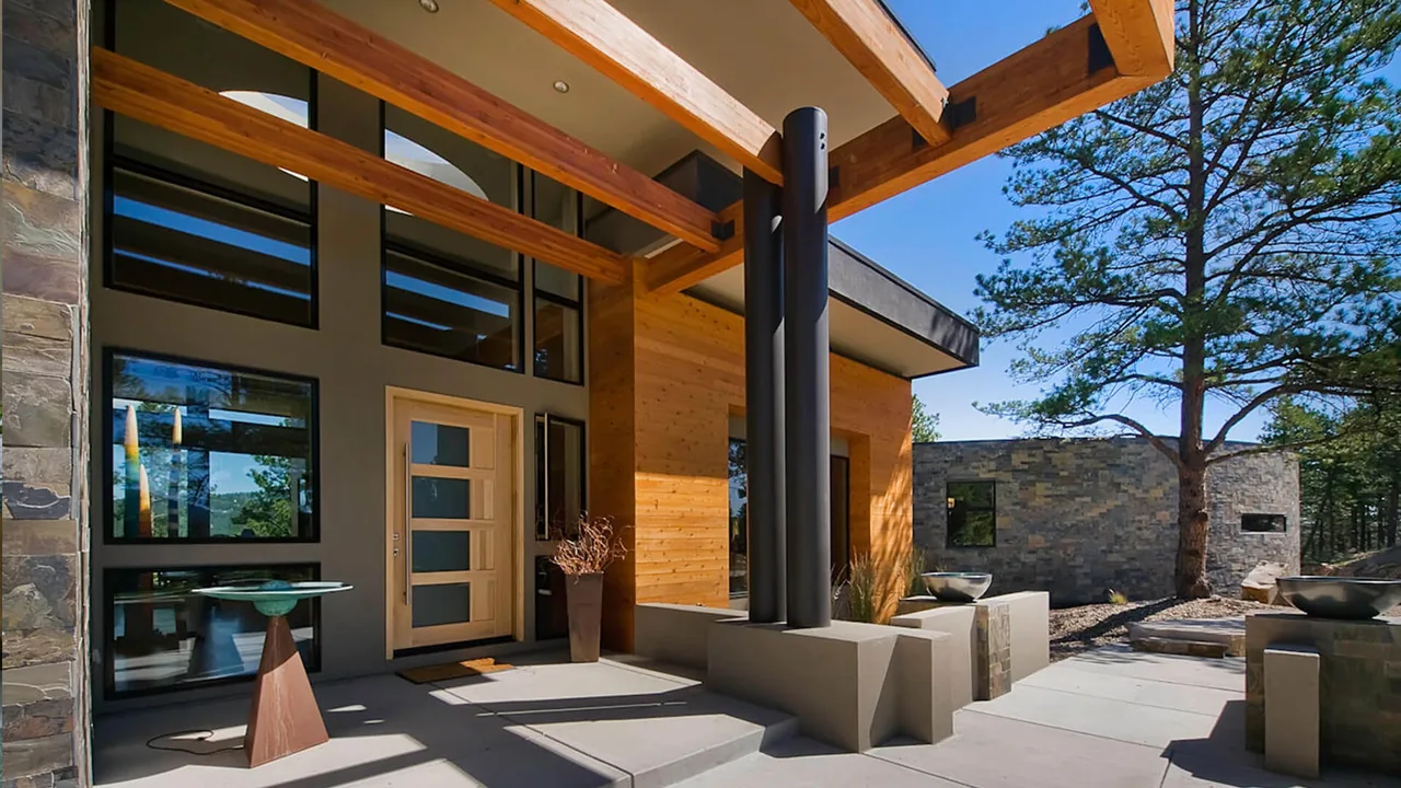 Evergreen Modern's front entrance uses wood panels, black steel columns, and expansive glass windows under a covered walkway designed by Entasis Group.