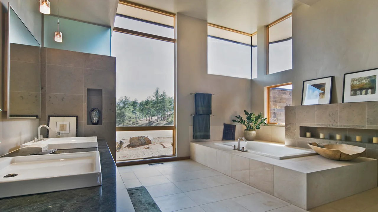 The Evergreen Modern bathroom features a built-in bathtub, dual sinks, and multiple large windows providing natural light and views.