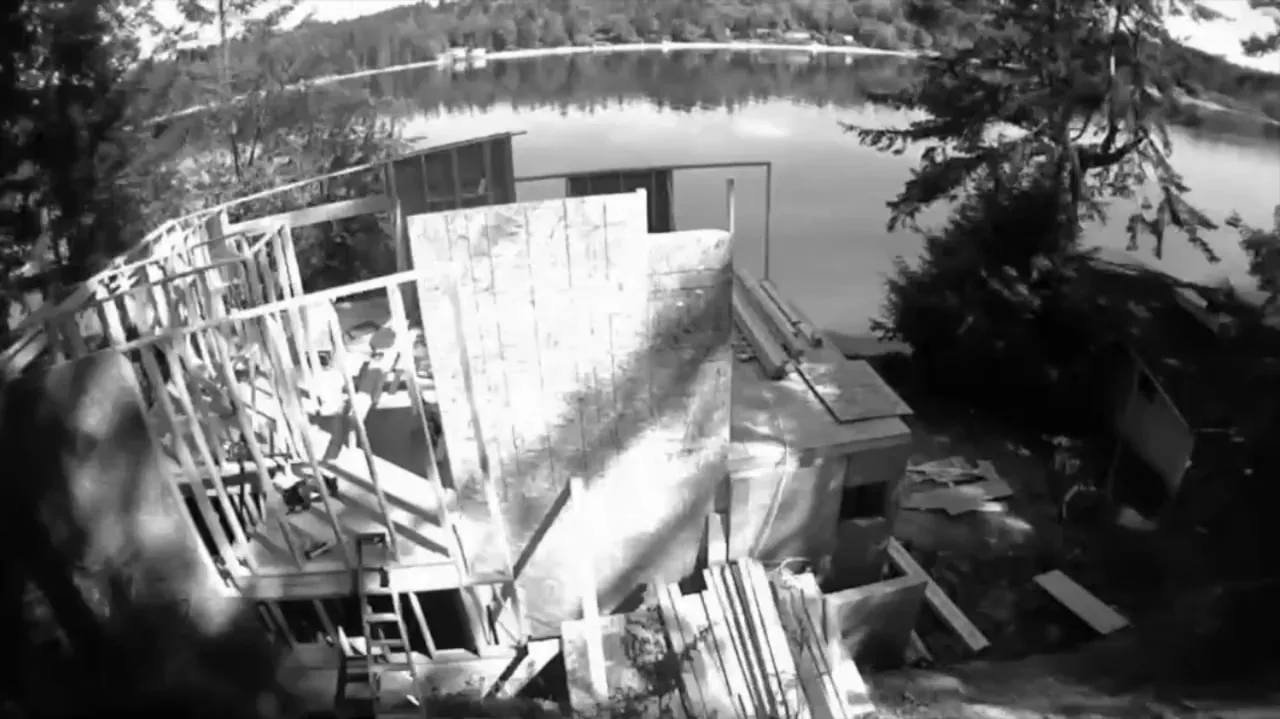 Herron Island Cabin under framing construction with lake and forest views in the background.