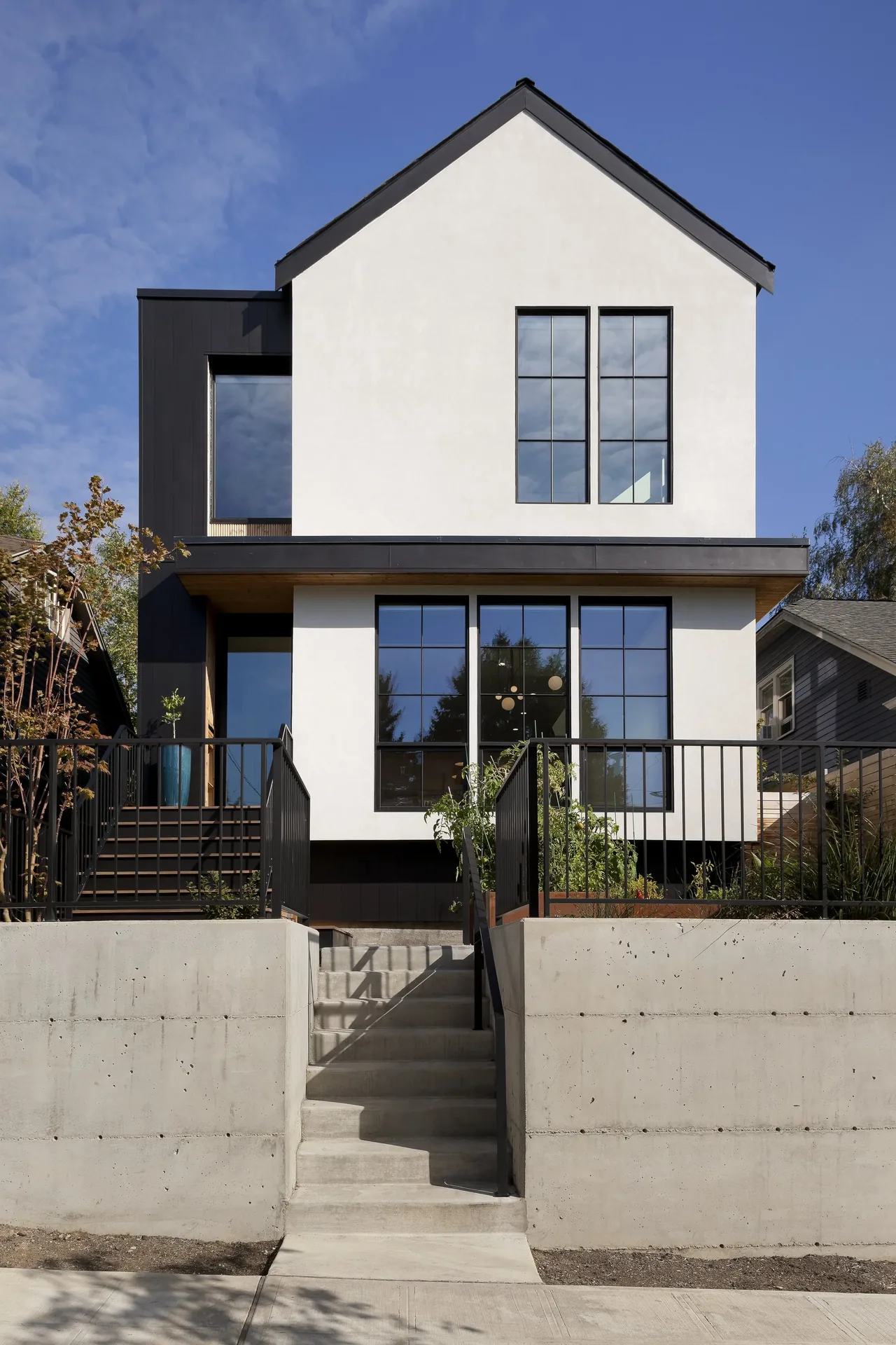 The Ravenna House features a modern exterior with black-framed windows and a concrete front stairway.