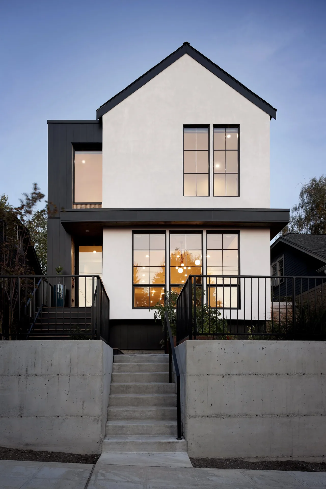 The Ravenna House features modern architecture with large grid-pattern windows and a concrete staircase entrance.