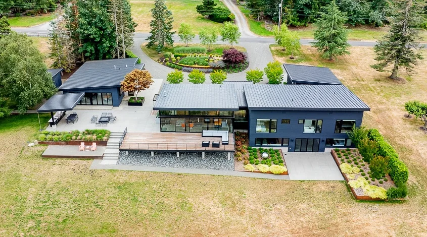 Cliff House ADU features a standing seam metal roof, large outdoor decks, and landscaped planter boxes.