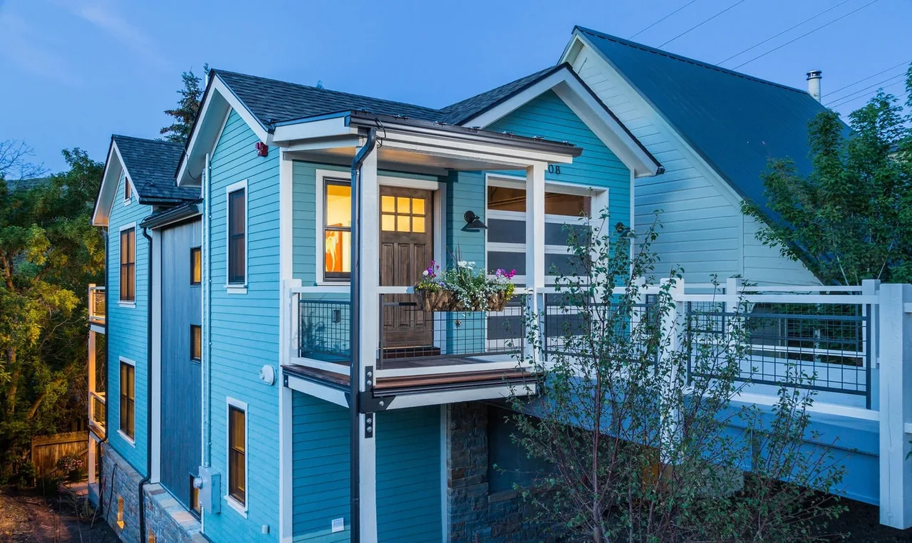 The Norfolk Ave 1 project features a blue exterior with a cantilevered balcony and pitched roof shapes.