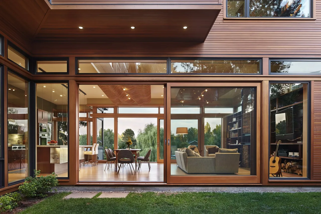 Exterior view of the Deschutes project showing large sliding glass doors connecting the living and dining spaces to the outdoors.