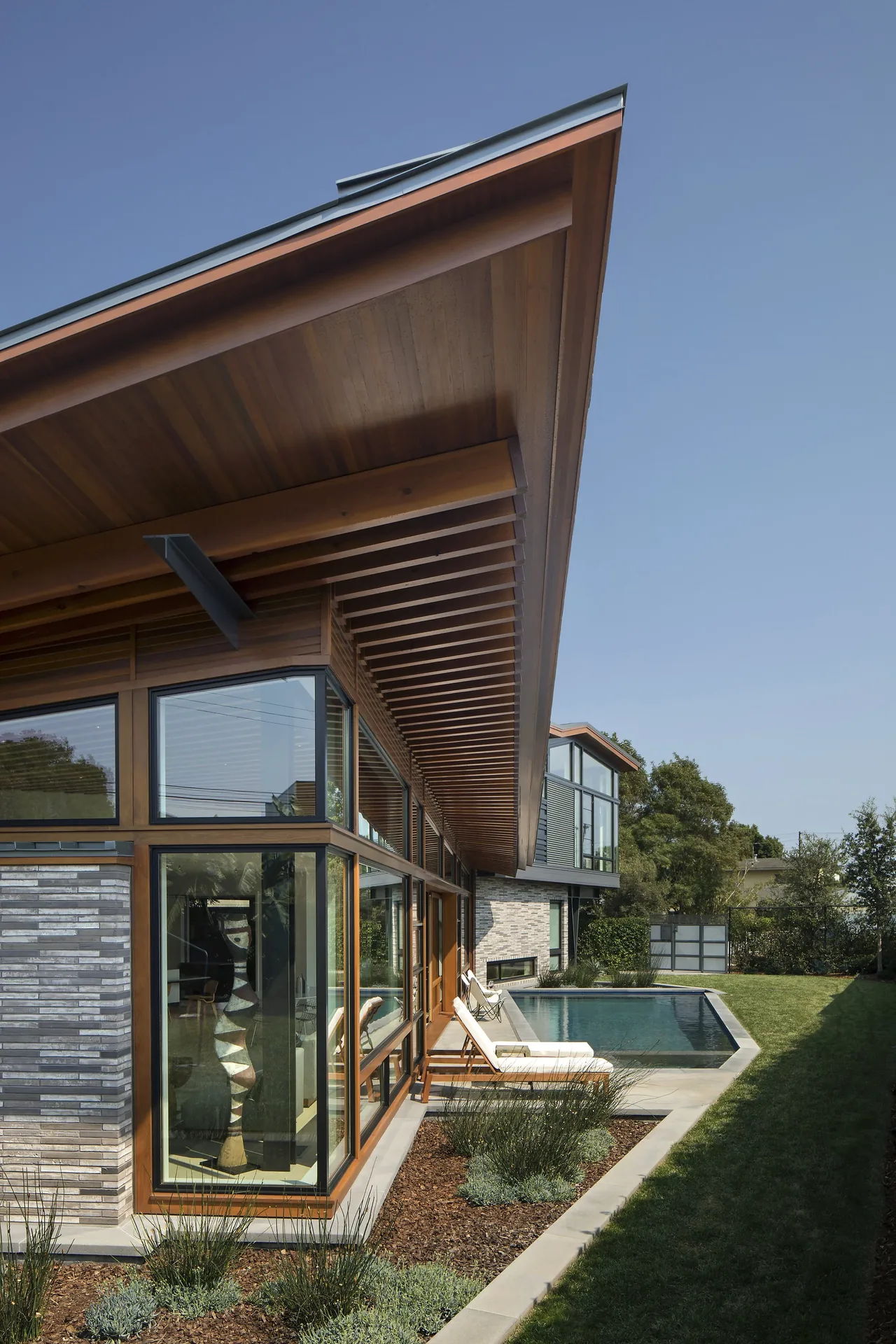 Venice project by FINNE Architects features a modern exterior with wood detailing, horizontal windows, and a narrow pool.