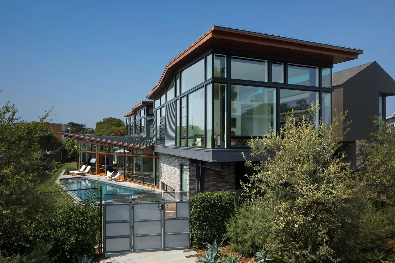 The Venice project by FINNE Architects features a modern home with extensive glazing and a narrow swimming pool.