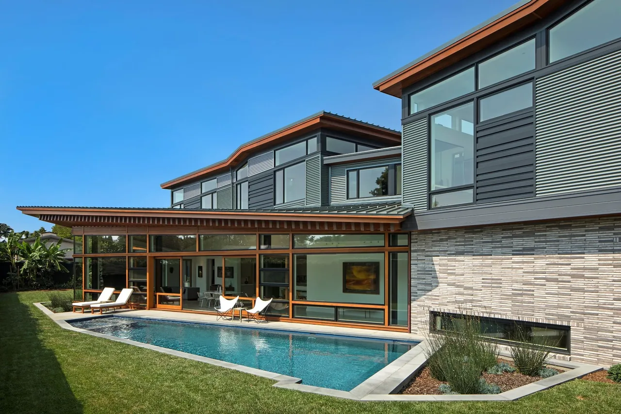 The Venice project by FINNE Architects features a narrow swimming pool and extensive black-framed glazing on the rear exterior.