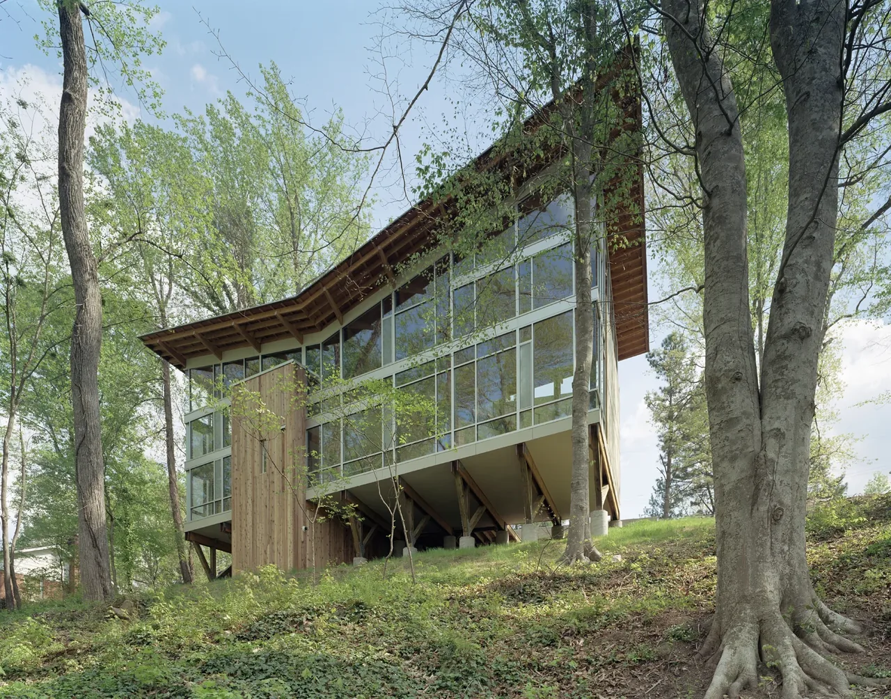 Strickland-Ferris Residence is an elevated modern home with extensive glazing and wood siding by Frank Harmon Architect PA.