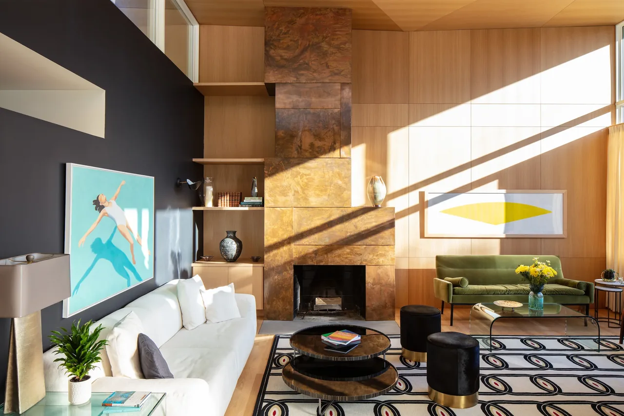 Living room in the Sepi Residence features a bronze-textured fireplace and wood-panel walls with contemporary artwork.