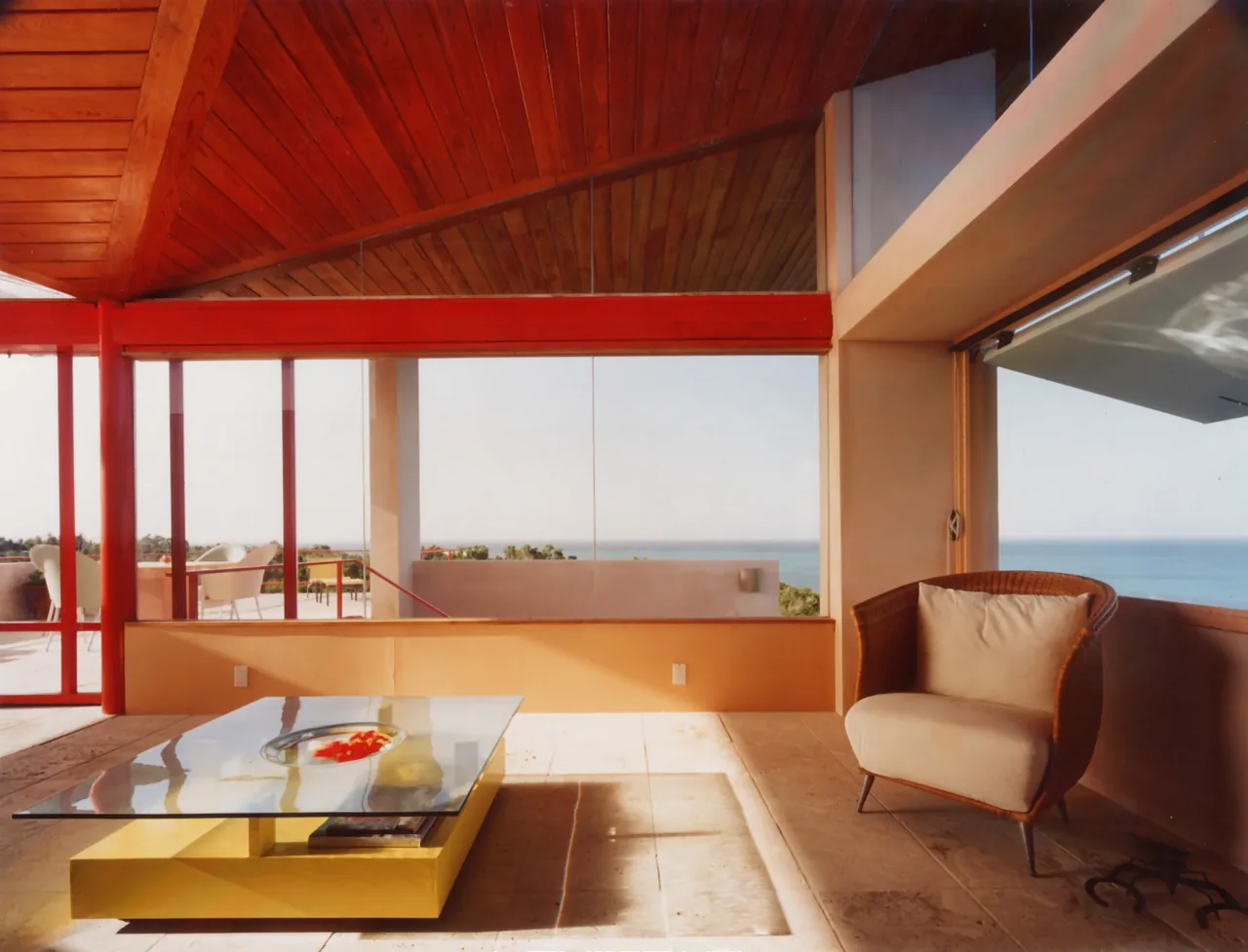 Living area with floor-to-ceiling glazing and a view of the waterfront at the Taylor Vacation Home.