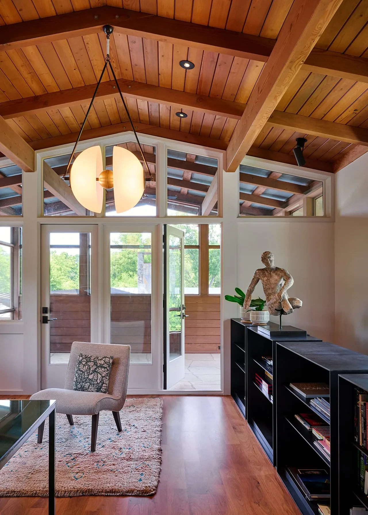 Living area features a vaulted wood ceiling with exposed beams and glass doors to a covered patio.