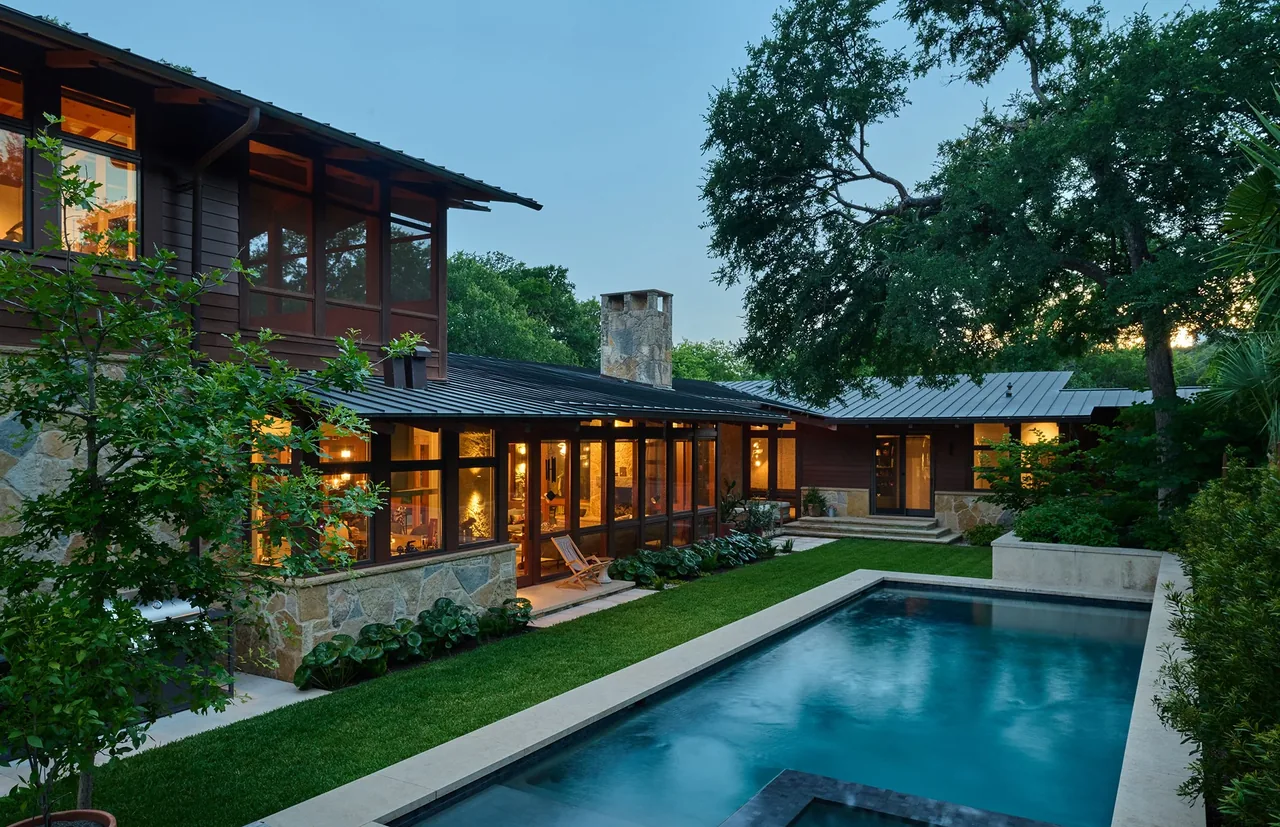 The FOOTHILL TERRACE house features stone base walls with dark wood and large windows, next to a rectangular pool and green lawn.