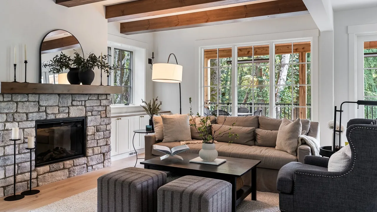 Living room features a stone fireplace with wooden mantle and large picture windows leading to an outdoor covered area.