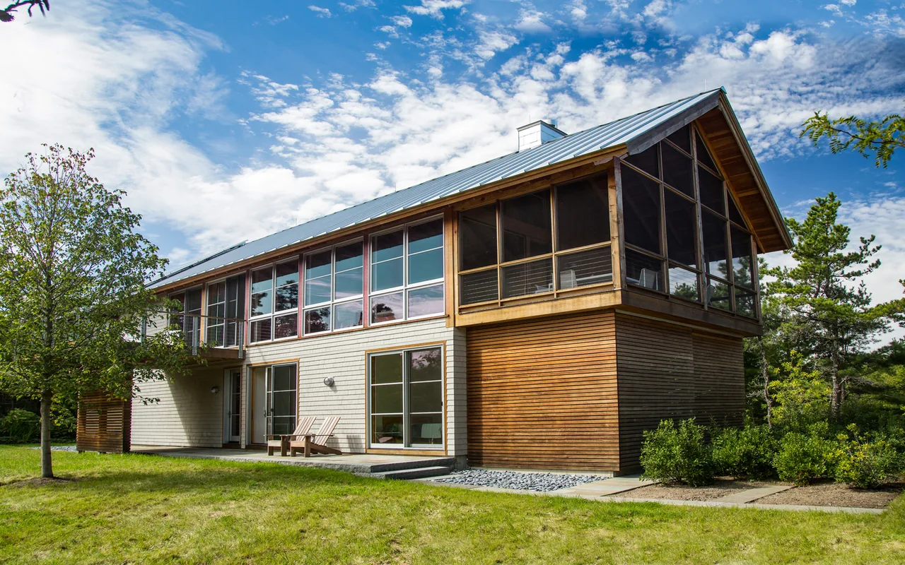 North Pamet Ridge House in Truro features mixed wood siding and large windows with a metal gable roof.