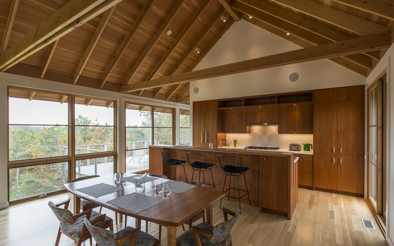 Open kitchen and dining space with vaulted ceiling and large windows in North Pamet Ridge House Truro by Hammer Architects.