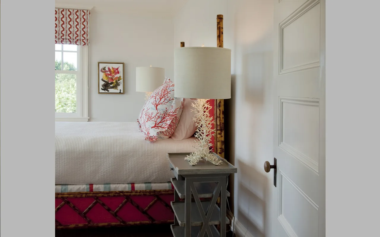 Bedroom corner with coral-themed decor, a bamboo bed frame, and a white door.