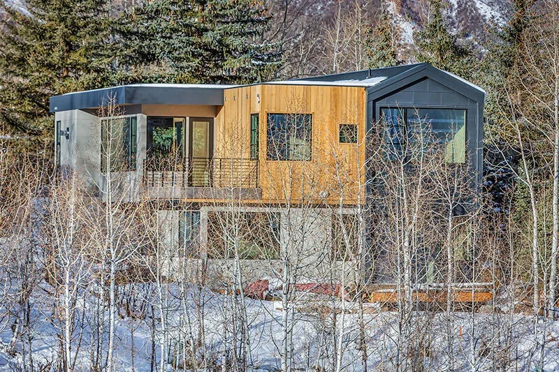 Snowmass Village Weekender is a modern two-story home with wood and dark metal exterior finishes and large windows.