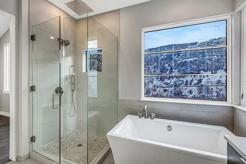 Bathroom featuring a freestanding tub with a snowy landscape view and a glass shower enclosure.