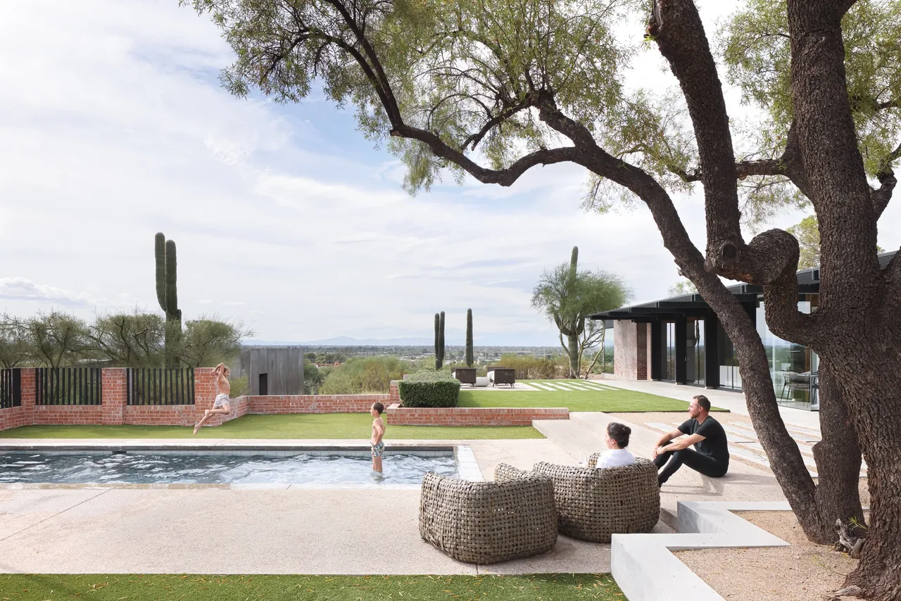 The casita OBSCURA features an outdoor pool and seating area overlooking desert vegetation and distant mountains.