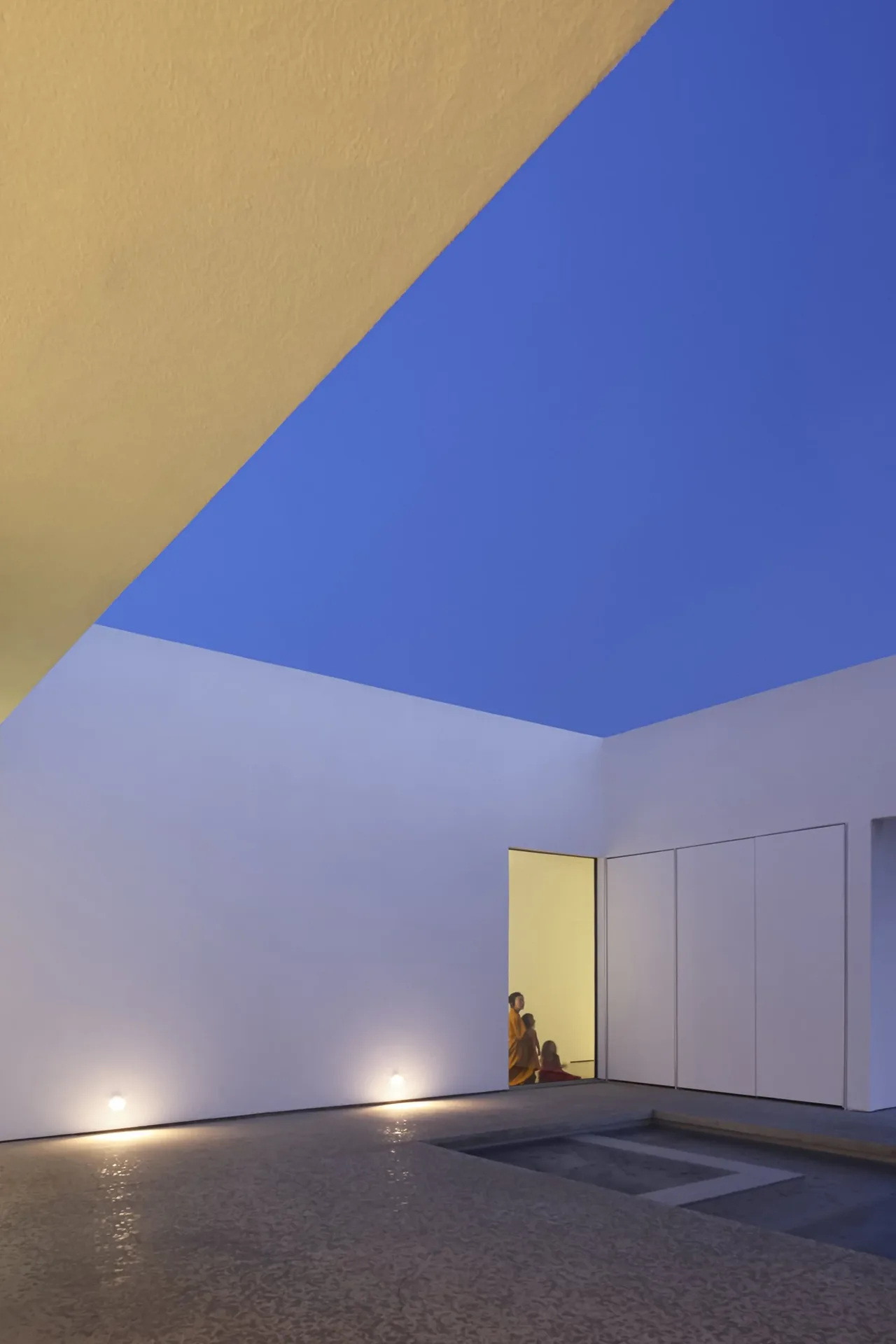 Minimalist white courtyard with clean lines and subtle lighting at dusk