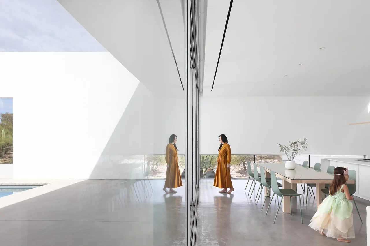 Bright modern dining area with floor-to-ceiling glass wall and polished concrete floor in the real house project.