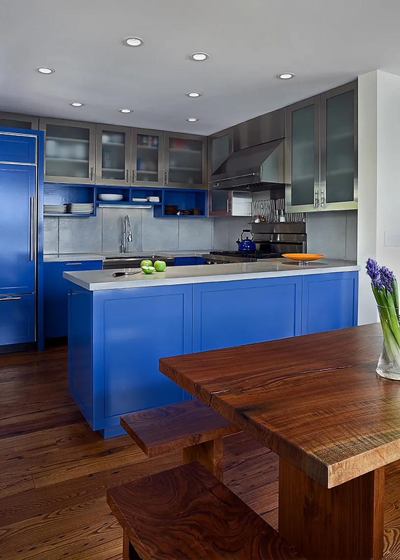 Interior view of the CONNECTICUT LAKE HOUSE kitchen with blue cabinets and wood dining furniture.