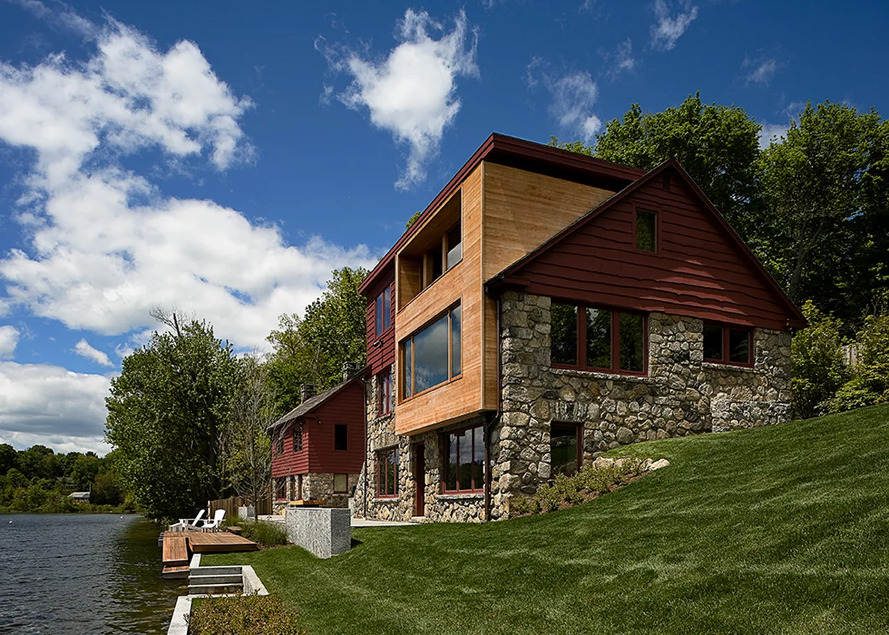 CONNECTICUT LAKE HOUSE by James Cleary Architecture features stone base and wood upper walls with large windows overlooking the lake.