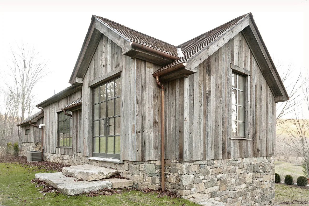 ROXBURY HOUSE exterior showing weathered wood siding and stone foundation with large multi-pane windows.