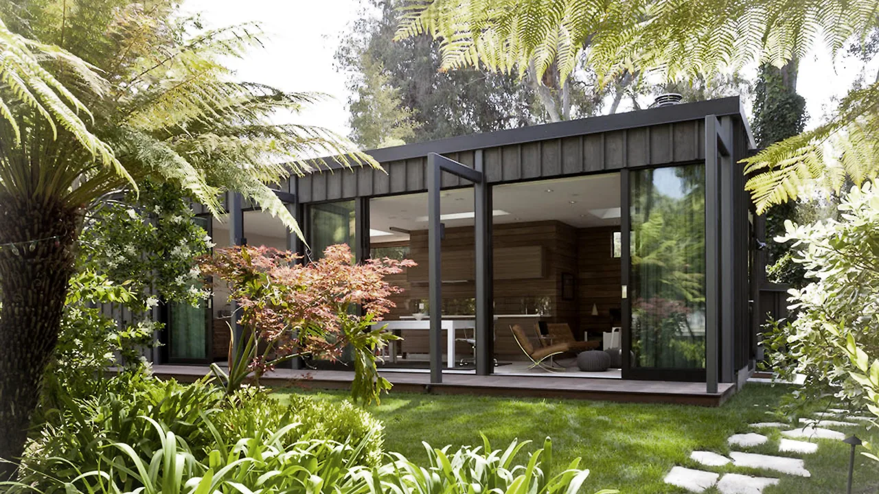 SANTA MONICA PAVILION by JENDRETZKI LLC features black metal framing and floor-to-ceiling glazing opening to a garden.