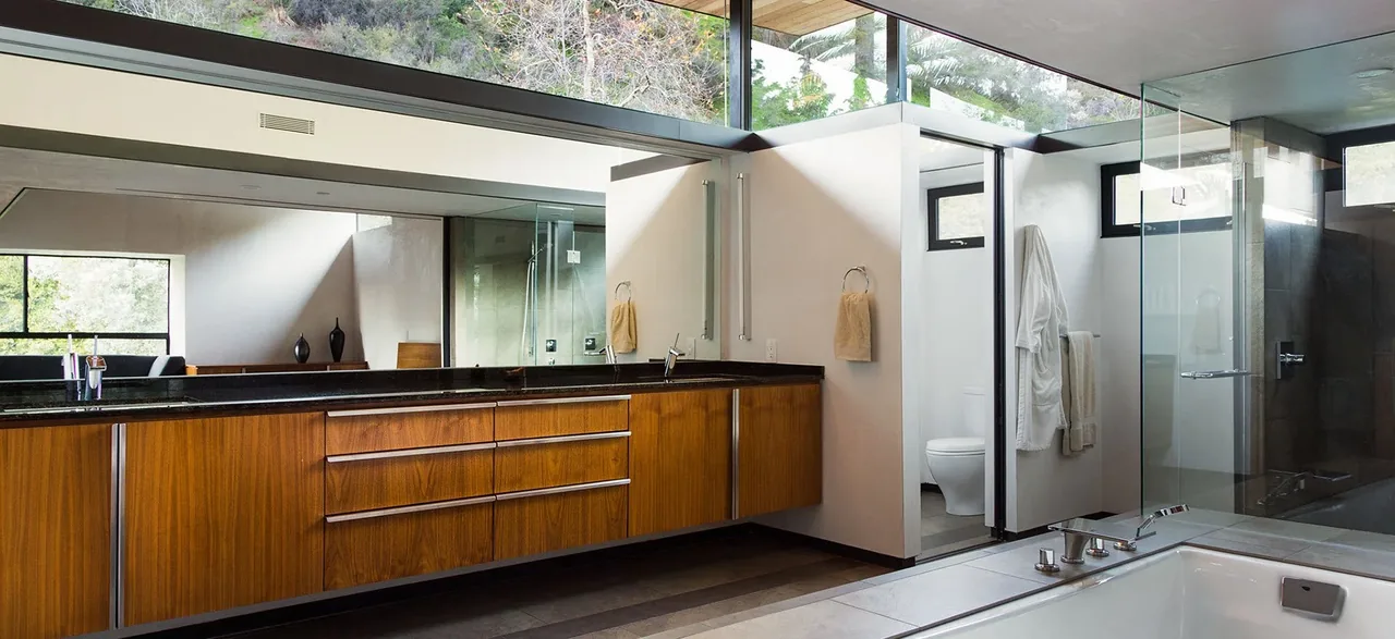 The bathroom features a wood-paneled floating vanity with dual sinks and a glass-enclosed walk-in shower.
