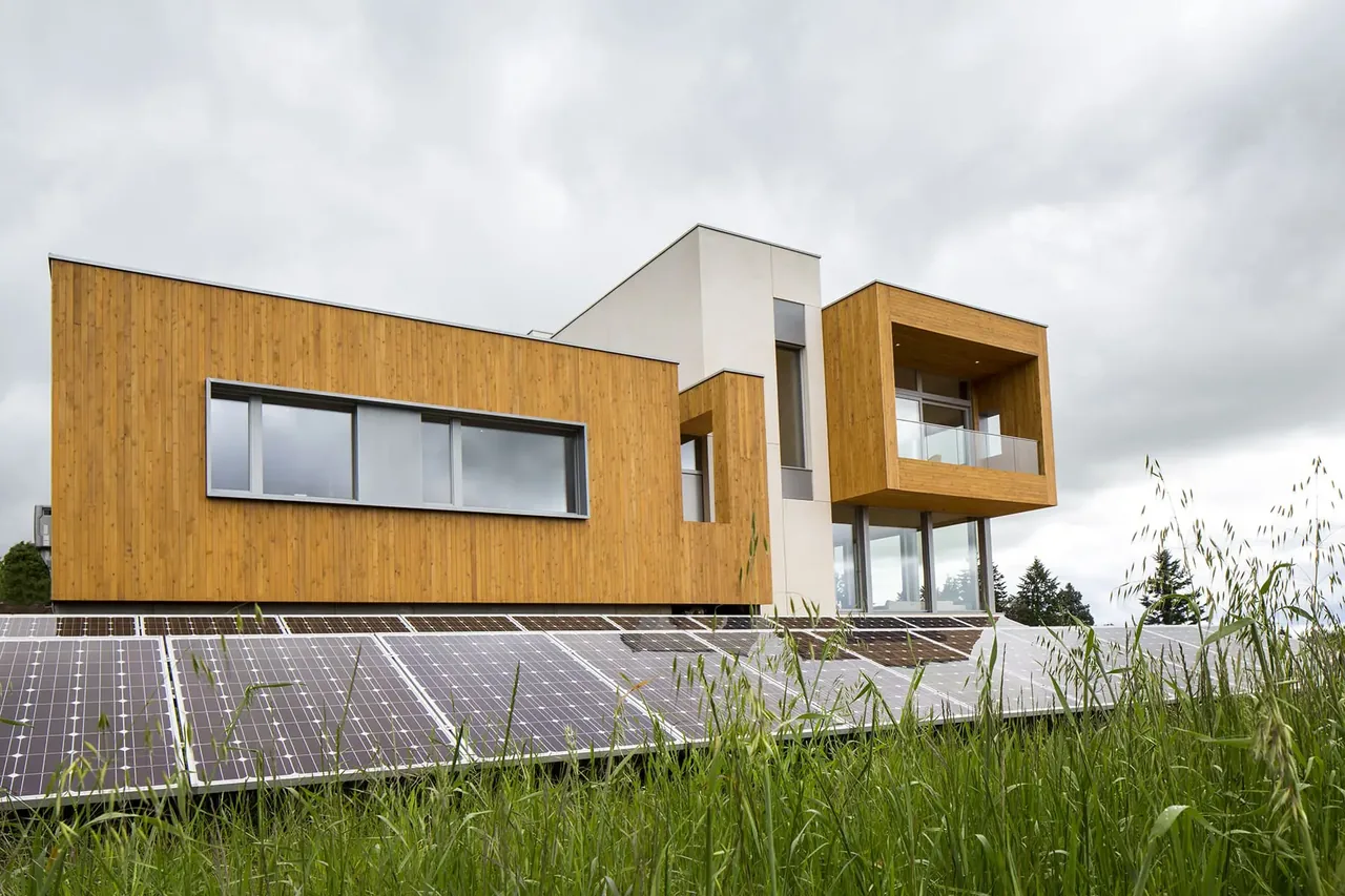Karuna House features cubic wooden volumes and extensive solar panels on the sloped roof, designed by Holst Architecture P.C.