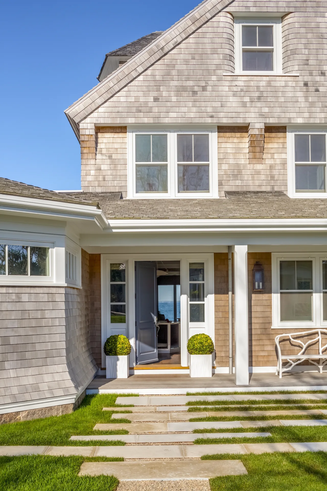 The West Bend Point house features wood shingle siding and a front entry with double doors and sidelights.