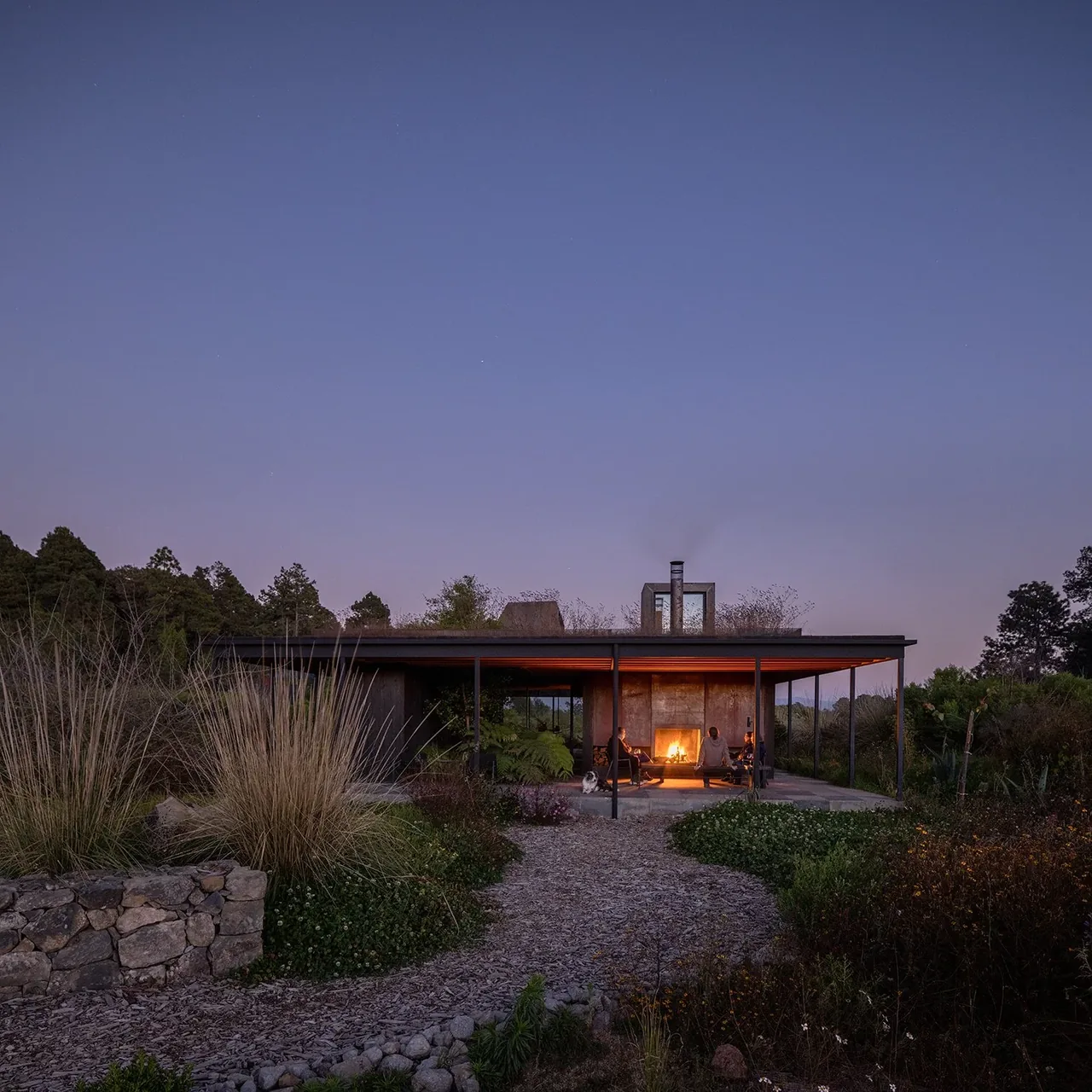 Casa Temascaltepec features a courtyard with a fireplace and a flat roof, blending with its natural landscape.