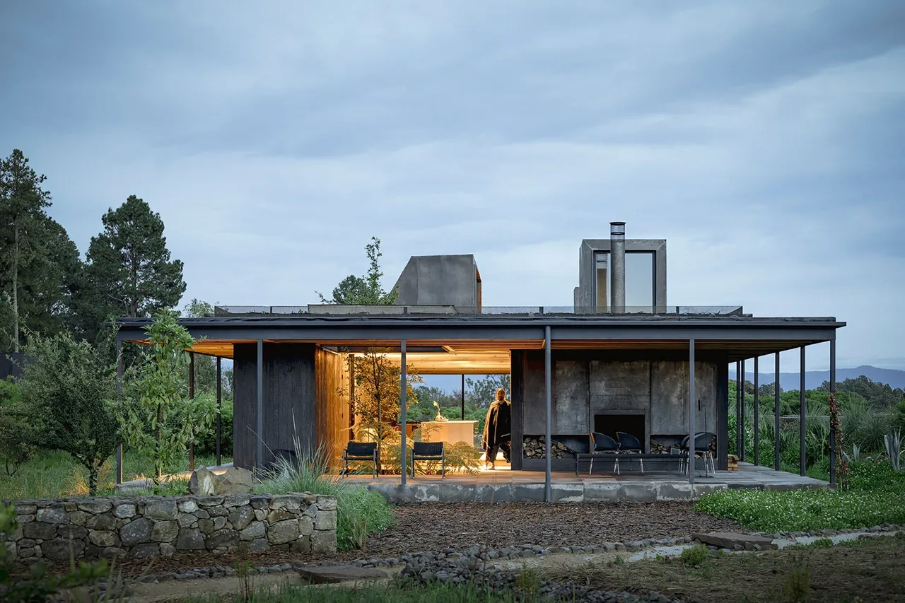 Casa Temascaltepec features a flat roof, expansive glazing, and a sheltered outdoor patio integrated with nature.