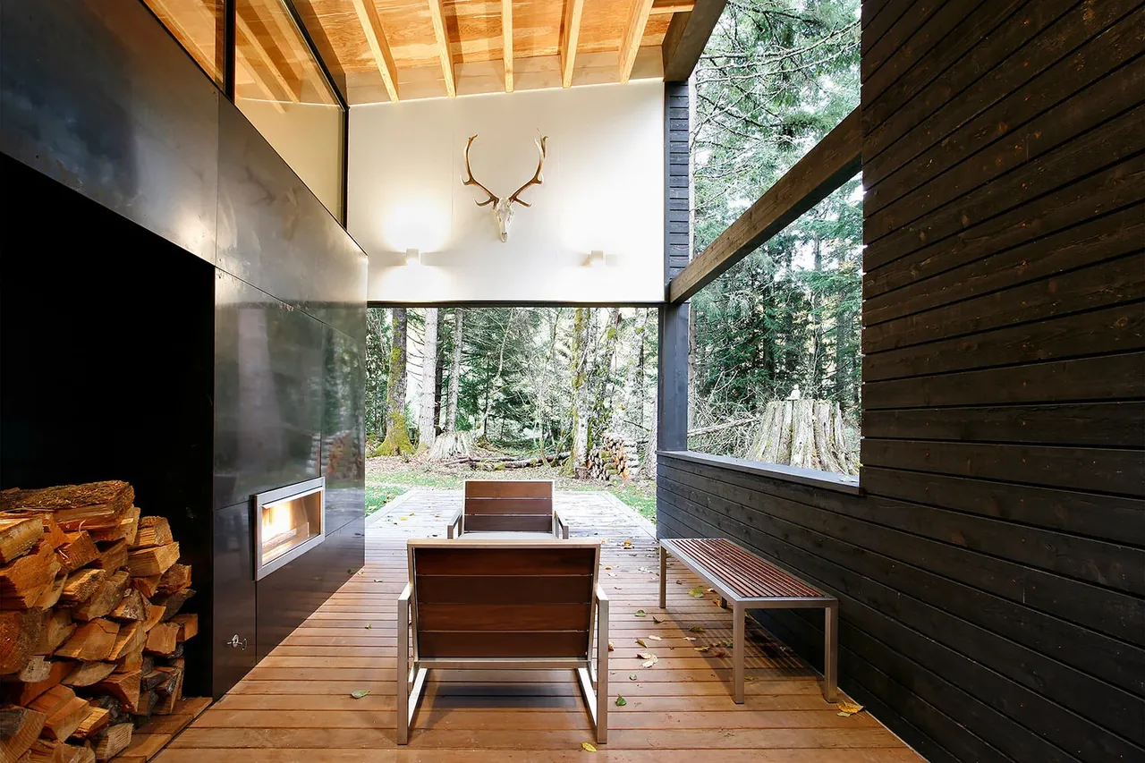 The courtyard's covered outdoor patio features modern wood and metal chairs, a built-in metal fireplace, and a wood ceiling with beams.