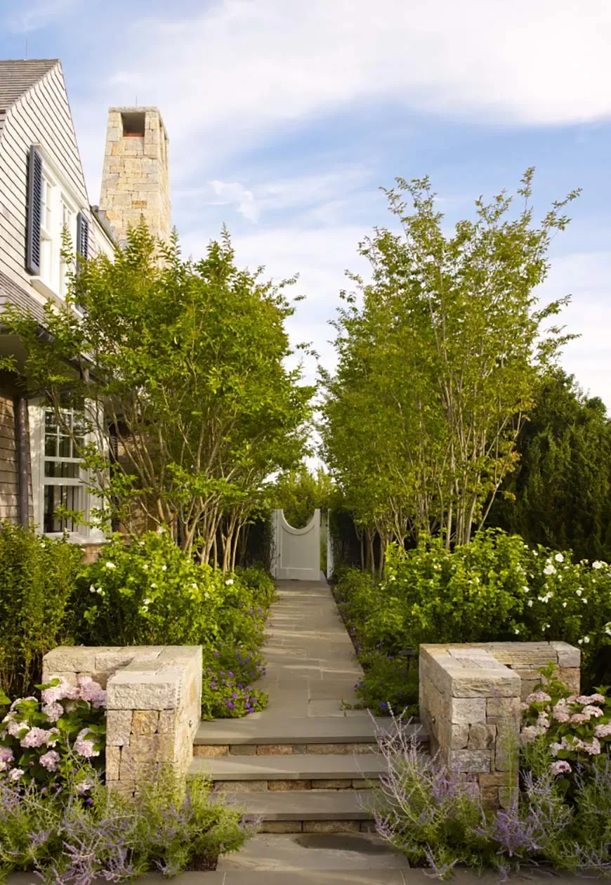 Landscaped garden path with stone steps and a white arched gate at the Sagaponack Beach Front Hideaway.